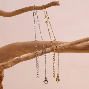 Elegant 14K gold and silver heart-linked stainless steel bracelets on natural wood branch