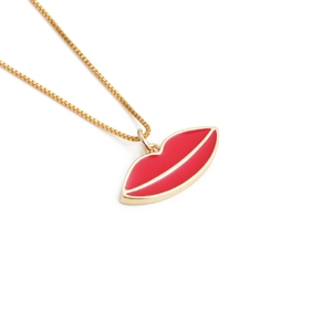 Golden box chain necklace featuring a minimalist red lip pendant on white background