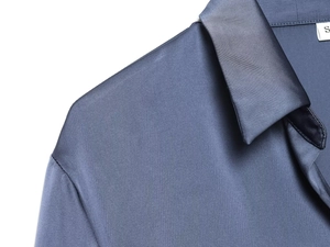 Close-up of a blue satin shirt collar with size S label and smooth silk fabric texture