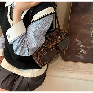 Detail view of leopard print shoulder bag with double front pockets and gold hardware