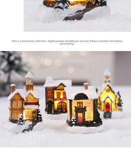 Detailed view of glowing miniature Christmas village house with warm LED lights and faux snow