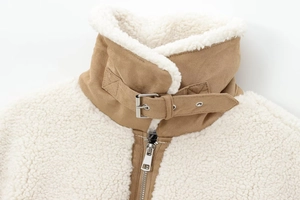 Detail of color-block fleece jacket showing lapel buckle and metal zipper texture