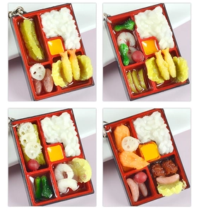 Macro shot of miniature Japanese bento box keychains with realistic food details