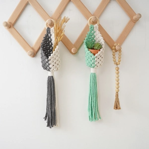 Detail of bohemian handmade cotton rope hanging baskets with natural wood bead garland