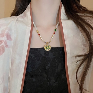 Detail der Perlenkette mit chinesischem Fu-Anhänger aus Gold am Ausschnitt des Modells