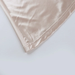 Gros plan détaillé du satin couleur champagne avec double couture professionnelle sur l'ourlet