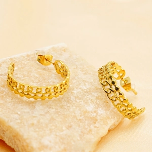 Macro shot of 18K gold-plated C-shaped earrings with chain texture and hollow floral patterns