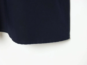 Gros plan des coutures de l'ourlet et du tissu bleu foncé sur une robe chemise courte