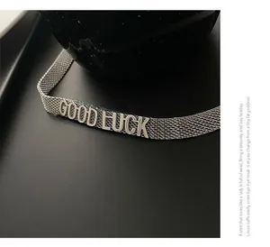 Détail du collier en maille milanaise argentée avec lettres Good Luck en relief 3D