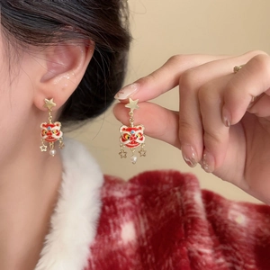 Detail of Chinese style lion dance earrings with red enamel, gold stars and pearl tassels