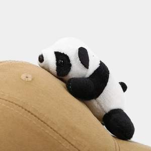Close-up of the cute 3D plush panda attached to a khaki cotton baseball cap with fine stitching