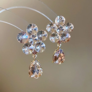 Macro shot of sparkling champagne crystal flower earrings with waterdrop shaped pendants