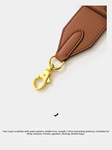 Close-up of brown leather 5cm wide palm grain shoulder strap with gold lobster clasps