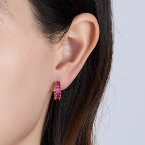 Detailed macro view of gold plated earrings featuring vibrant square-cut pink zircon stones