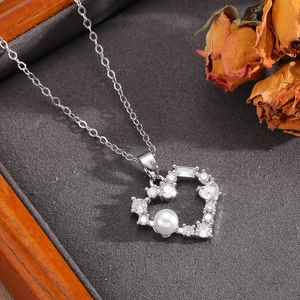 Dettaglio della collana con cuore in argento con cristalli lucidi e perla bianca