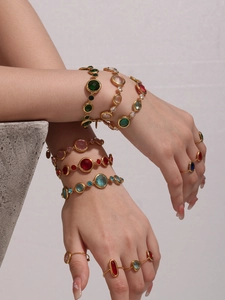 Close-up of luxury gold-plated bracelets and rings set with vibrant colorful gemstones