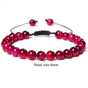 Detail showing 6mm pink tiger eye beads with adjustable black braided cord on white background