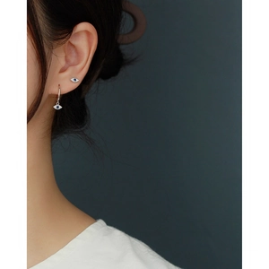 Detailed view of S925 sterling silver evil eye earrings with blue zircon on model ear