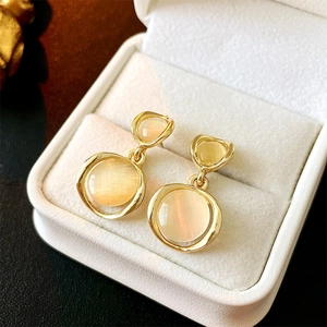 Elegant gold cat eye stone hoop drop earrings displayed in a luxury jewelry box