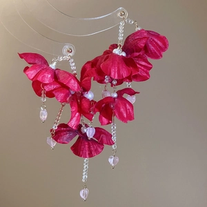 Detail of red fabric flower earrings with white pearls and pink heart crystal drop