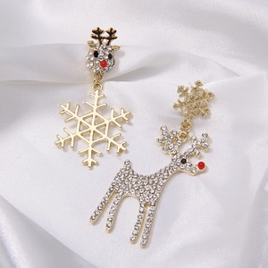 Close-up of asymmetrical Christmas reindeer and snowflake studs on white silk fabric