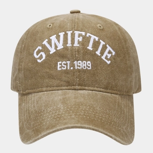 Detailed white embroidery of SWIFTIE and EST. 1989 on a washed khaki cotton baseball cap