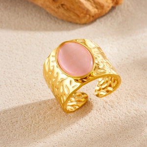 Wide gold hammer textured stainless steel open ring with oval pink gemstone inlay