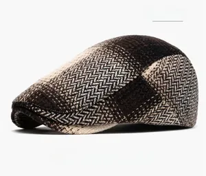 Détail de la casquette gavroche marron café montrant le motif chevrons et le tweed