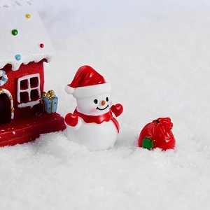 Set natalizio in resina con pupazzo di neve, casa rossa e sacchetto regalo sulla neve