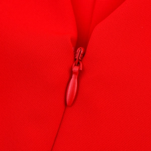 Dettaglio della cerniera invisibile su abito rosso con scollo a V e trama del tessuto