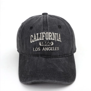 Detailed view of white California embroidery on washed denim baseball cap in dark grey