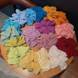 Set of colorful chiffon hair scrunchies in 14 vibrant colors on a wooden background