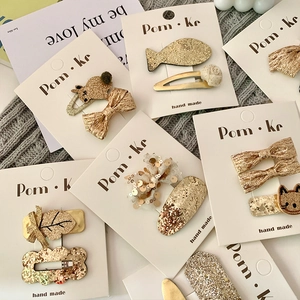 Sparkly champagne gold sequin bow and animal hair clip set on a white display card