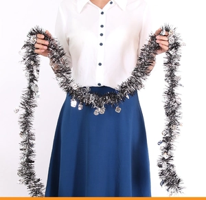 Detail of black Halloween tinsel with silver skull sequins held by hand for party decor