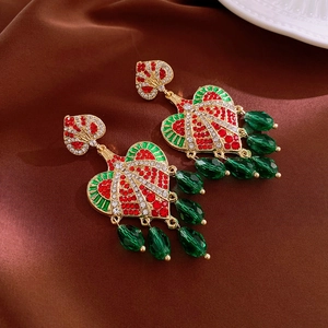 Detail of vintage heart earrings with red rhinestones and green faceted beaded tassels
