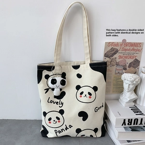Detail der Canvas-Einkaufstasche mit Pandadrucken und süßem Plüsch-Pandas-Anhänger