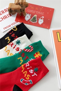 Détail de chaussettes de Noël en coton avec broderie Merry Christmas en quatre couleurs