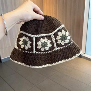Detailed close-up of handmade crochet bucket hat featuring colorful floral knit patterns
