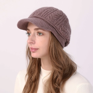 Detalle de gorro de punto trenzado morado con visera mostrando la textura de la lana