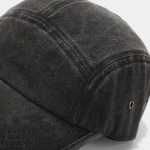 Macro detail of washed cotton fabric with double stitching and metal eyelets on camp hat