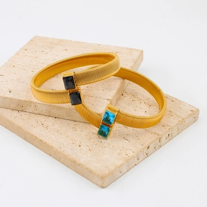 Gouden roestvrijstalen getextureerde armband met blauwe en zwarte edelstenen