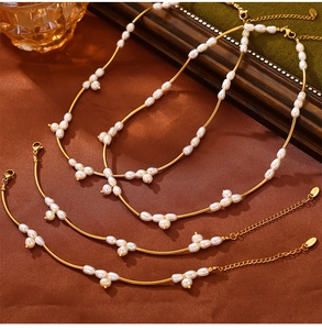 Detail of freshwater pearl necklace with gold bar design on brown silk base