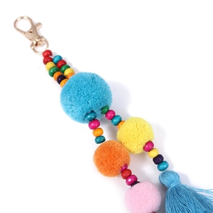 Dettaglio portachiavi boho colorato con pompon di peluche, perline di legno e nappa di cotone
