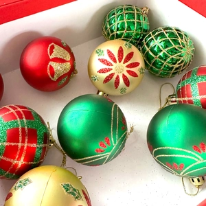 Assorted Christmas ball ornaments in red, green, and gold with glitter and painted designs
