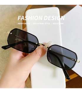 Detail of retro small frame sunglasses with gold metal temples and black lenses