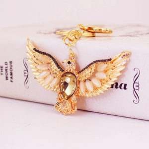 Vintage golden eagle keychain with amber crystal and sparkling rhinestones on a white book