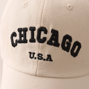 Detailed close-up of CHICAGO U.S.A black embroidery on a beige cotton baseball cap