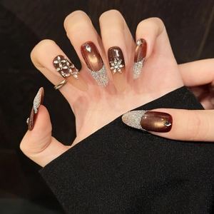 Brown cat-eye press-on nails with luxury rhinestones and long stiletto shape