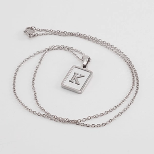 Detailed shot of letter K silver square pendant necklace with white shell inlay