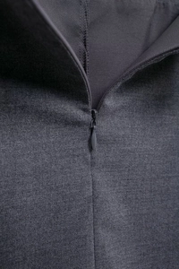 Detailed close-up of invisible zipper and textured grey fabric on pleated mini skirt
